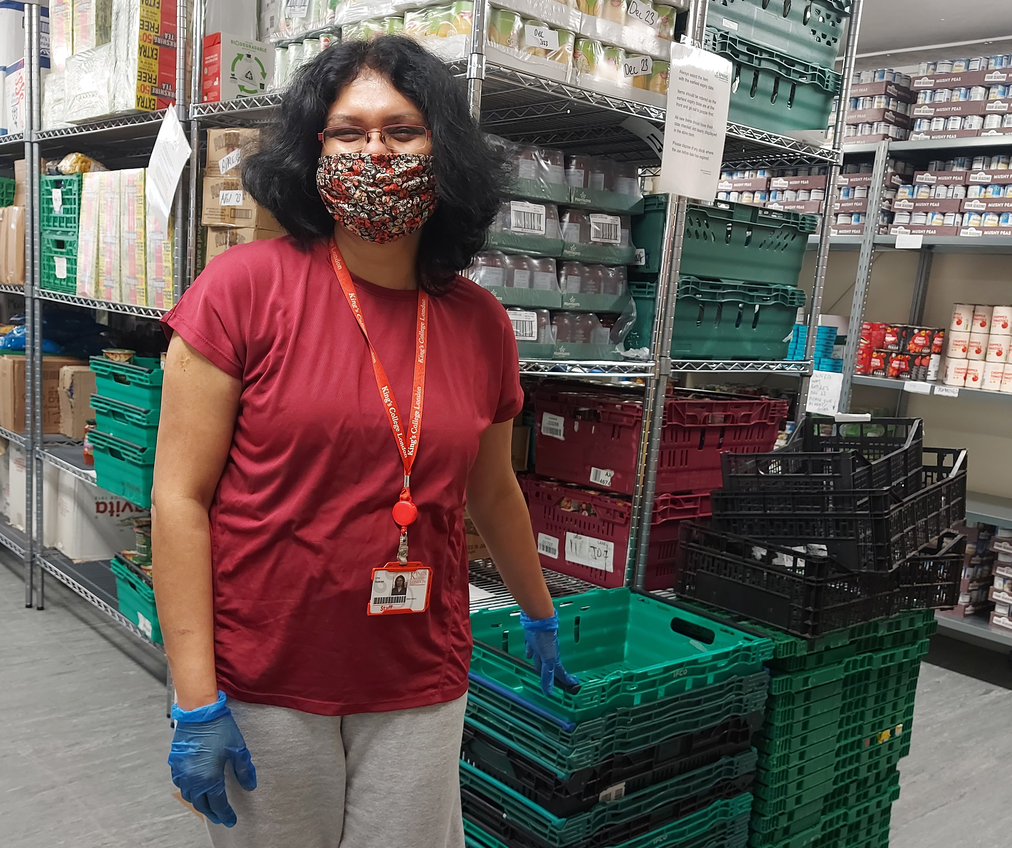 volunteer stands by crates in the foodbank warehouse