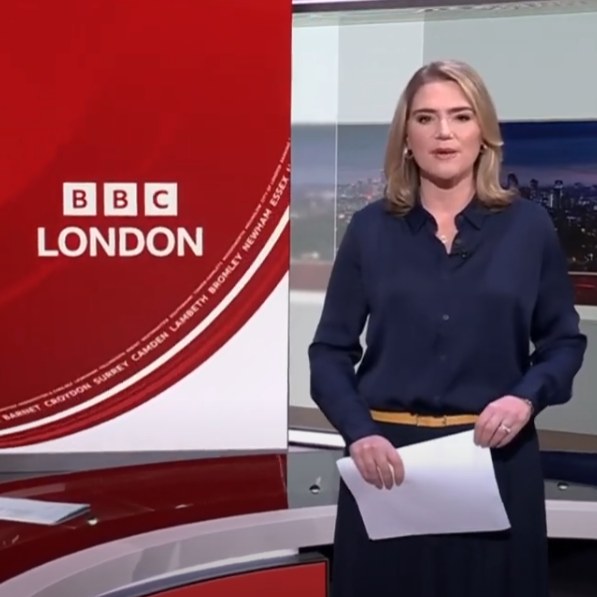Female newsreader on wet standing by the BBC London logo