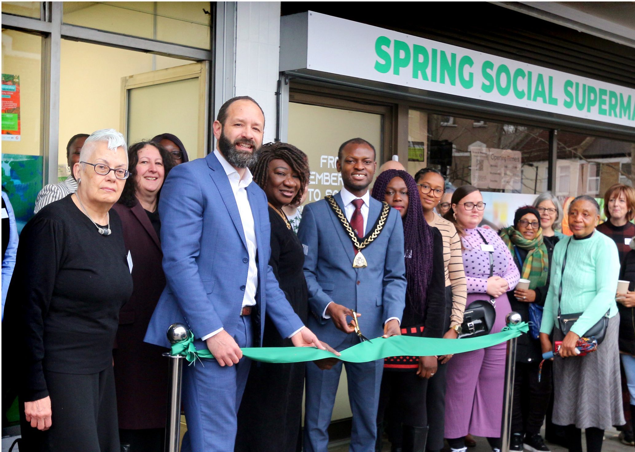 A crowd of people in front of the new premises watch as the mayor od southwark cuts the official opening ribbon