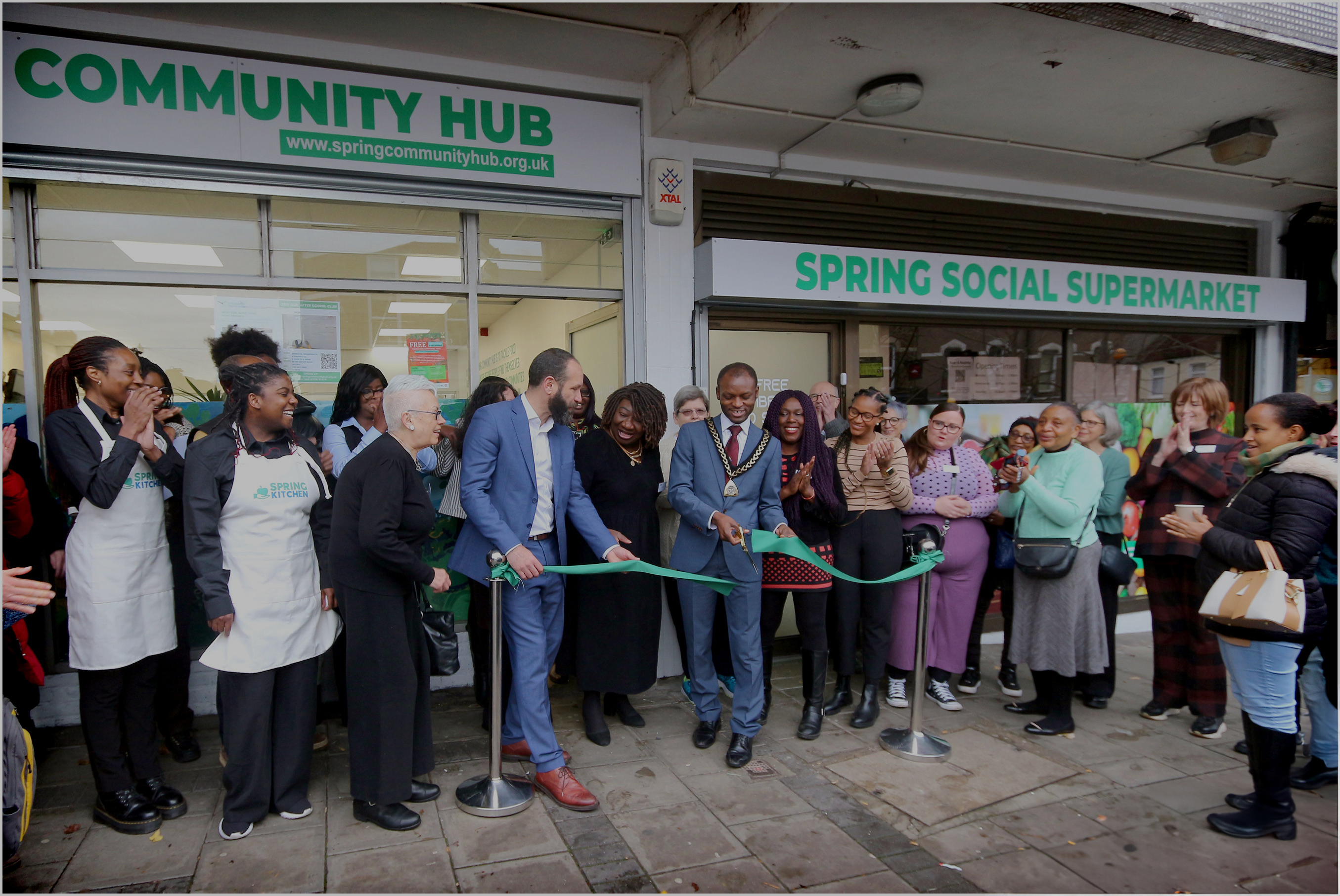 A group of people outside The Hub as the mayor cuts the ribbon at the official opening