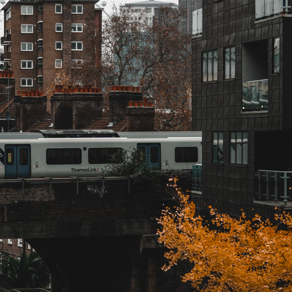 A thameslink train going over a bridge between blocks of flats