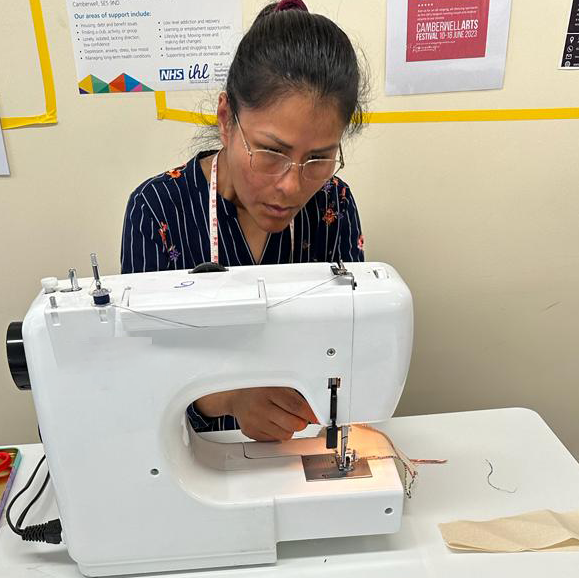 A woman using a white sewing machine
